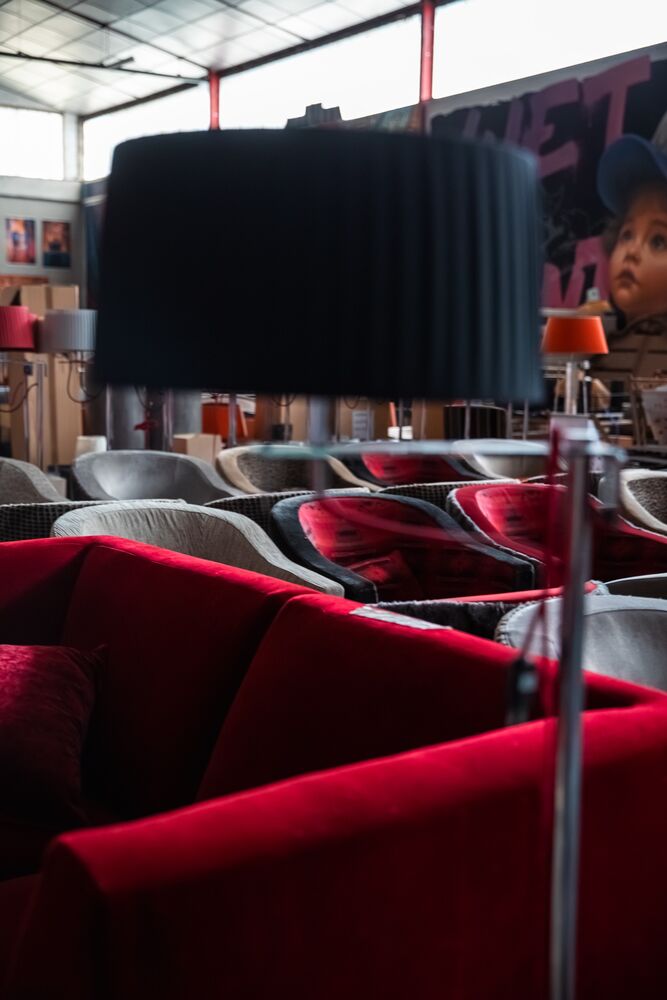 Grand lampadaire noir au-dessus d'un canapé en velours rouge